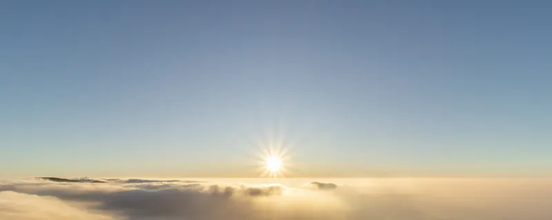 The sun rising above a sea of clouds, seen from the Vanjangi hilltop